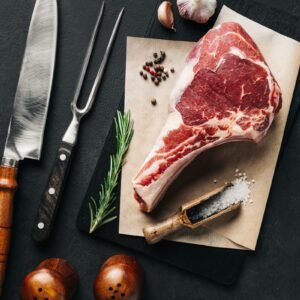a piece of meat sitting on top of a cutting board next to a knife